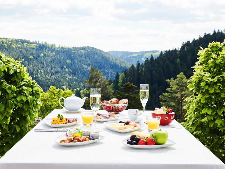 Ein reichlich gedeckter Frühstückstisch auf der Panoramaterrasse des Restaurants Berlins Lamm mit Blick in den Schwarzwald.