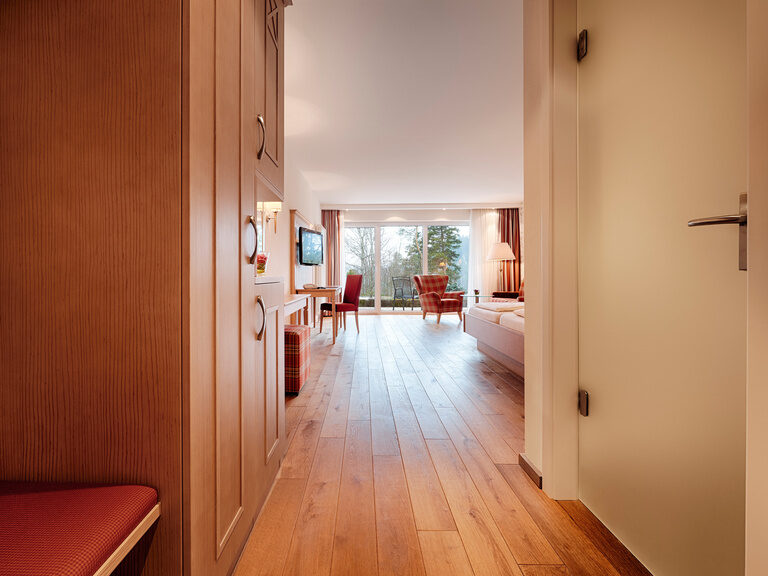Ein Zimmerflur des Hotelzimmers gibt einen Einblick über den Grundriss des Zimmers und den Wohn- und Schlafbereich.
