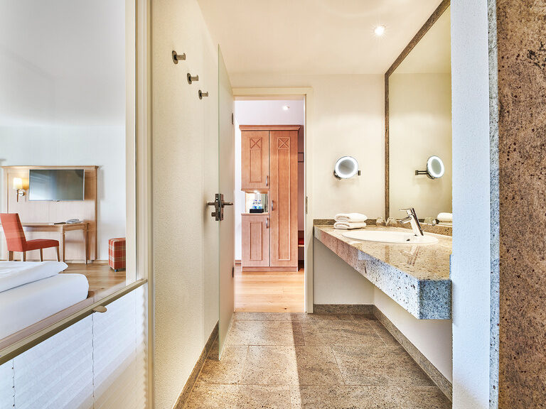 Das schicke Bad im Zimmer Waldparadies mit Waschbecken und Spiegel