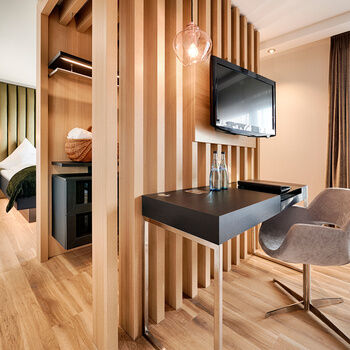 A living area in the Junuirorsuite Burgherrengemach with modern furniture and wooden floors in the Hotel KroneLamm in the Black Forest.