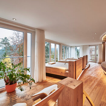 Wasserbetten, Liegen und eine große Liegefläche in einem Raum mit großen Panoramafenstern und Blick in den Schwarzwald.