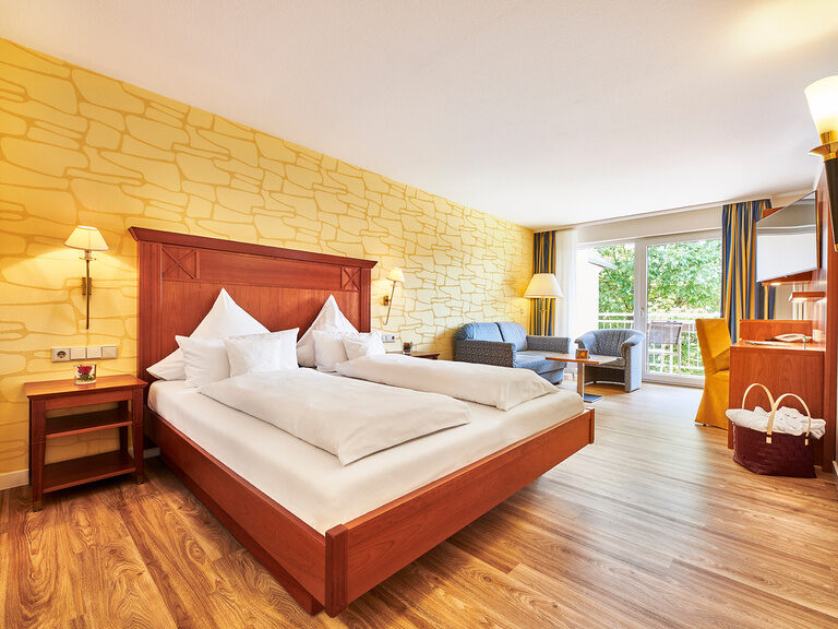 The large double bed in the Buwinghausen room with chic furniture in the Hotel KroneLamm.