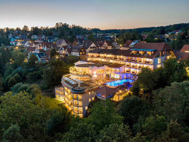 Illuminated exterior view of the Berlin KroneLamm wellness hotel in the Black Forest in the evening