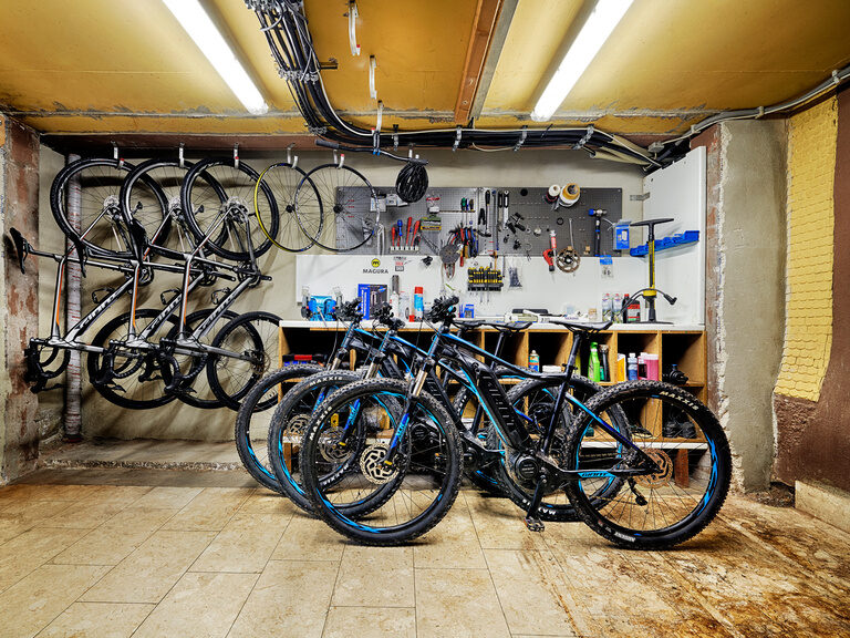 Many different bicycle, e-bike and mountain bike models are standing and hanging in one room.