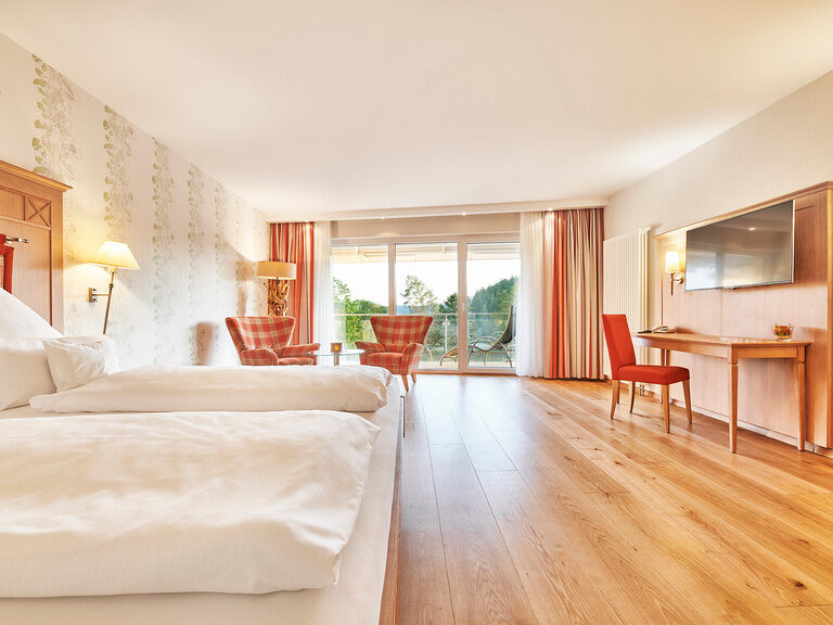 The bright forest paradise room in the Hotel KroneLamm with a double bed and wooden floor.