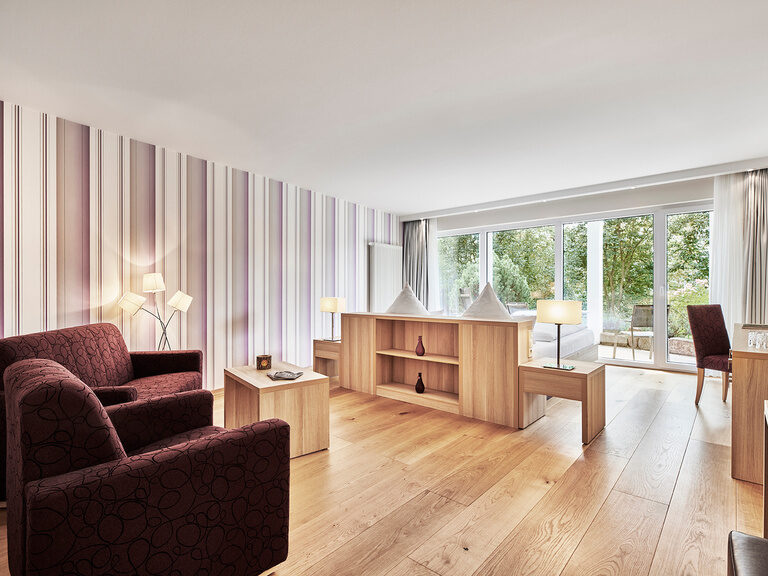 Das helle Wohnzimmer in der Traumbett-Juniorsuite mit edlen Möbeln im Hotel Berlins KroneLamm.
